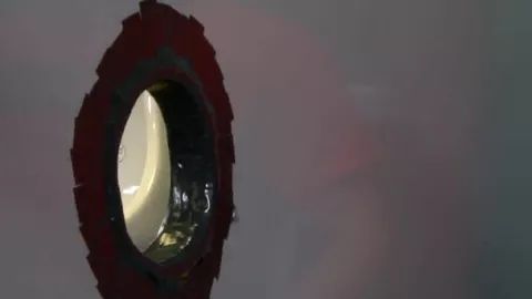 Un mec suce une bite à travers un gloryhole dans les vestiaires