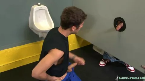 Un pibe mama una polla por un gloryhole en los vestuarios