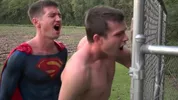Jovem superman come um cara num campo de futebol