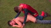 Jovem superman come um cara num campo de futebol