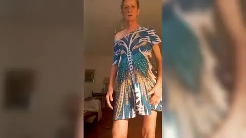 En robe bleue à fleurs, nu dessous